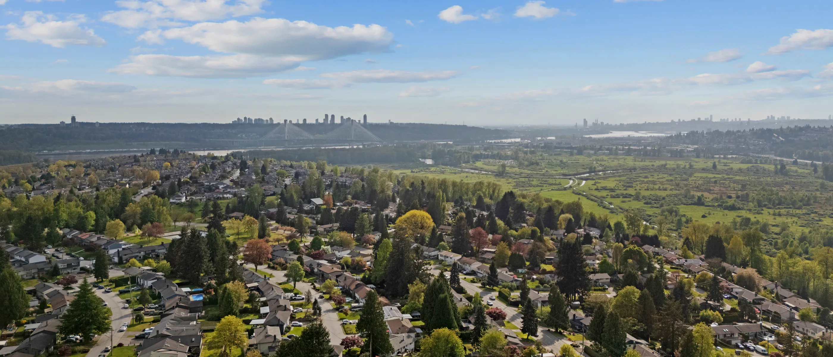 Aerial view over a Coquitlam neighbourhood with the Coast Mountains behind